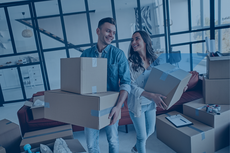 Casal transporta caixas para nova casa após aprovação de crédito habitação com apoio especializado da Maxfinance Dream.
