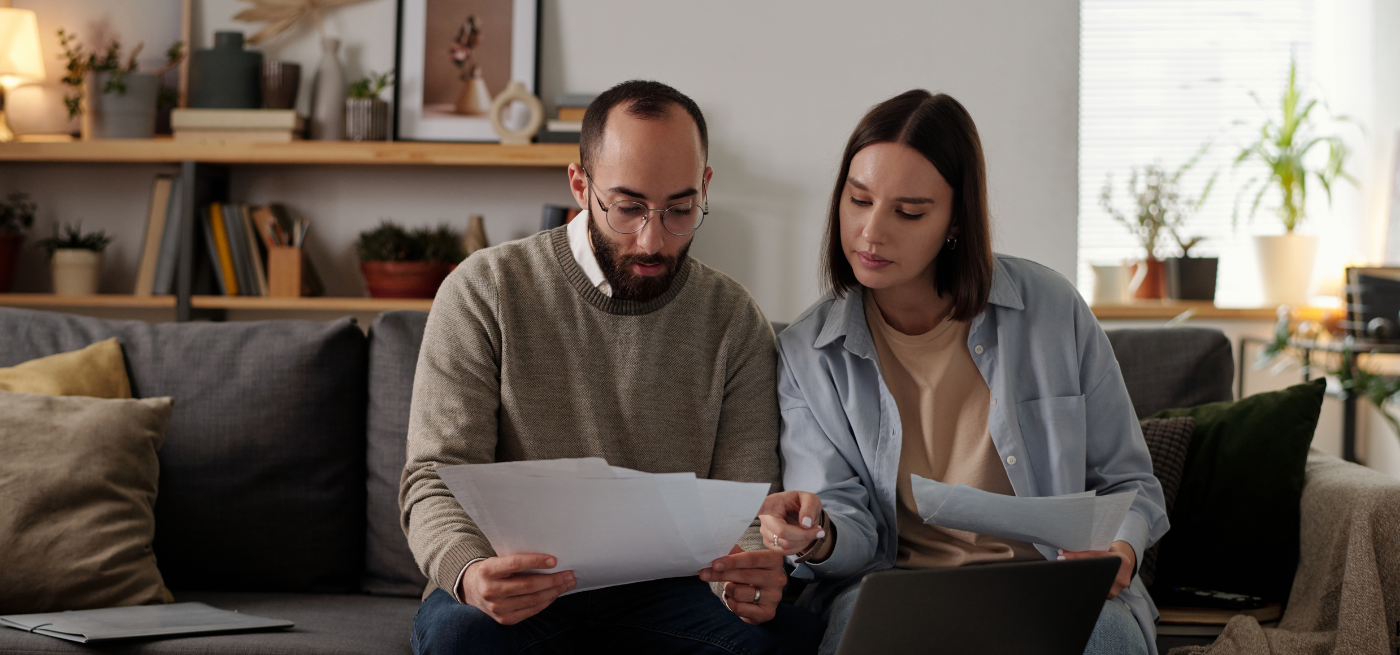Casal em casa a analisar documentos e orçamento antes de comprar casa